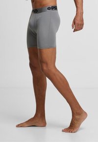Boxer briefs gris avec une taille noire arborant la marque "PSD". Fabriqués dans un matériau extensible. Design ajusté.