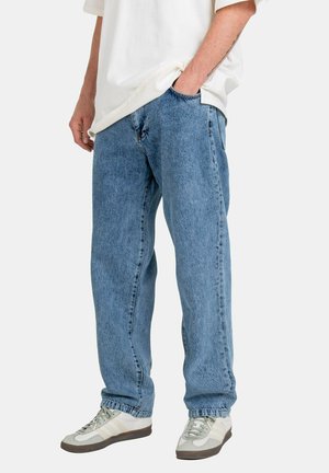 Blue denim jeans with a relaxed fit, featuring five pockets and a classic design. Worn with white and gray sneakers. Casual look.