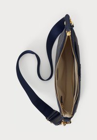 Taschenhandtasche aus navyfarbenem Leder mit strukturiertem Äußeren, goldener Reißverschluss und Leinengurt. Geöffnet, zeigt ein hellbeiges Innenfutter mit Taschen.