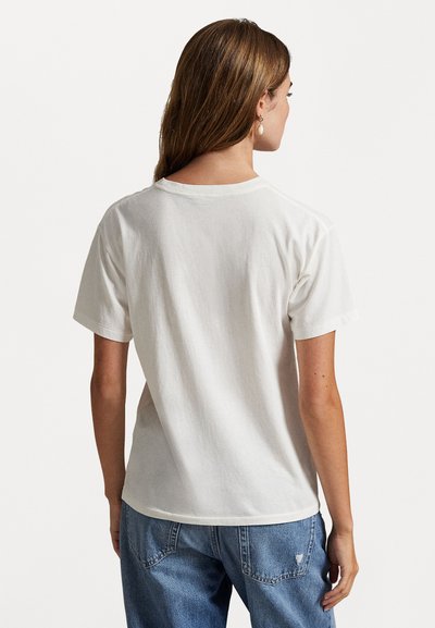 White cotton t-shirt with a rounded neckline and short sleeves, featuring a relaxed fit and a smooth texture. Back view shows simple design.