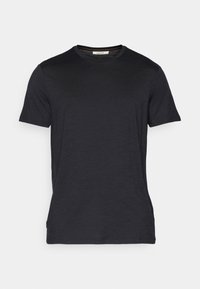 Schwarzes T-Shirt mit kurzen Ärmeln aus einem weichen, strukturierten Stoff. Mit Rundhalsausschnitt und dezenten Nähakzenten entlang des Ausschnitts.
