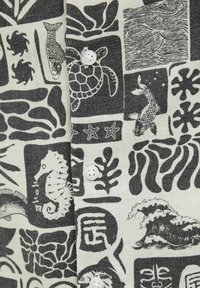 Camisa de tela de manga corta con un patrón acuático en blanco y negro que presenta varias criaturas marinas y texturas, con detalle de cierre de botones.