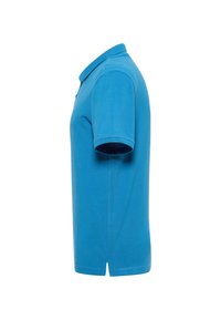 Tyrkysové polo tričko s klasickým límečkem, krátkými rukávy a rovním střihem. Má zapínání na knoflíky a postranní rozparky na spodním lemu.