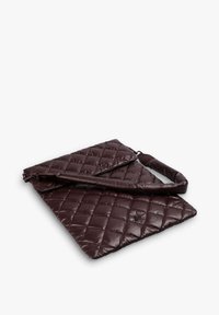 Bolso bandolera acolchado en color marrón oscuro, con correa ajustable, de forma rectangular y con un sutil detalle del logo en la solapa frontal.