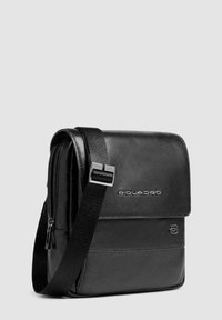 Borsa a messanger in pelle nera con finitura liscia, tracolla regolabile, patta frontale e dettagli del logo; presenta un vano con zip.