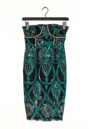 Robe noire bustier avec broderie florale et géométrique verte et ornements en perles argentées suspendue sur un cintre noir.