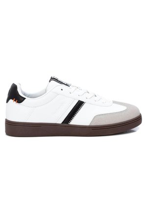 Zapatilla blanca con acentos en negro y gris, con un upper de cuero liso, puntera de gamuza texturizada y suela de goma marrón.