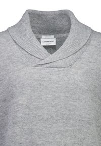 Grå lamullströja med sjalkrage, avslappnad passform och ribbad textur. Etikett synlig inuti med varumärket "Lindbergh."