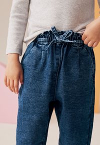 Pantaloni jogger in denim con vita elastica e lacci, caratterizzati da una vestibilità comoda e due tasche laterali, di colore blu scuro.