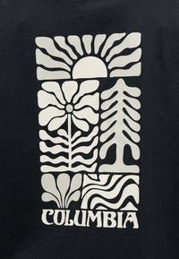 Μαύρο ύφασμα με λευκό αφηρημένο σχέδιο πουλιού, λουλουδιού, δέντρου και φύλλου, με το κείμενο "COLUMBIA" κεντραρισμένο από κάτω.