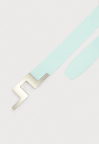 Φωτεινή γαλάζια ζώνη με μεταλλικό ασημί γεωμετρικό κούμπωμα. Ο ιμάντας έχει λεία υφή και είναι επίπεδος, με καθαρό, μίνιμαλ σχέδιο.