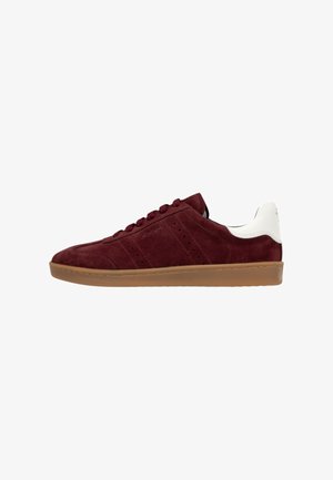 Burgundery Suede Sneaker mit weißer Ferse, Gummisohle, sechs Ösen und dezenten Belüftungsperforationen. Schlichtes, niedrig geschnittenes Design.