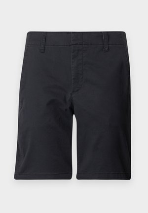 Μαύρα σορτς μήκους μέχρι το γόνατο με θηλιές για ζώνη και ορατή ραφή στο μπροστινό μέρος, απλωμένα επίπεδα σε λευκό φόντο.