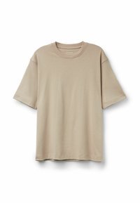 Béžové oversized tričko vyrobené z měkkého materiálu, s kulatým výstřihem a krátkými rukávy. Hladká textura bez viditelných vzorů nebo akcentů.