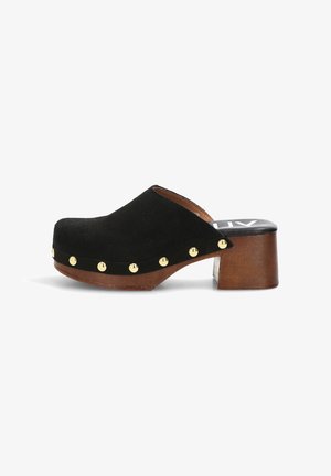 Zueco negro de ante con tacón redondeado de madera, tachuelas doradas a lo largo del borde de la suela y diseño sin cierre.