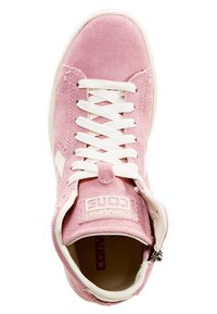 Baskets en suède rose avec lacets blancs, languette rembourrée et patch logo. Elles présentent une semelle en caoutchouc blanche et un détail zippé sur le côté.