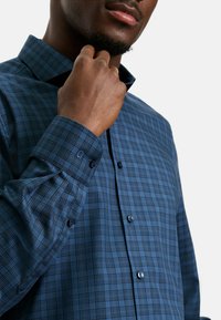 Blau kariertes Button-up-Hemd aus gewebtem Stoff, mit spitzem Kragen, Knopf-Akzenten und Manschette mit einer einzelnen Knopfverschluss.