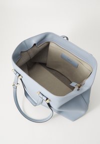 Borsa tote in pelle blu chiaro con finitura liscia, apertura superiore, tasche interne e dettagli in metallo dorato. Fodera interna in tessuto grigio.