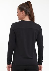 Schwarzes langärmliges Shirt mit rundem Halsausschnitt und glattem, dehnbarem Stoff. Verfügt über eine horizontale Naht über dem oberen Rücken.
