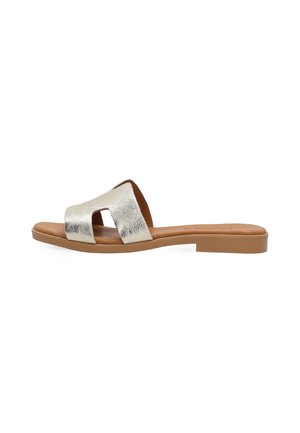 Flacher hellbrauner Sandale mit breitem metallic-silbernem Riemen mit Cut-out-Design, offenem Zehenbereich und niedrigem quadratischem Absatz vor weißem Hintergrund.