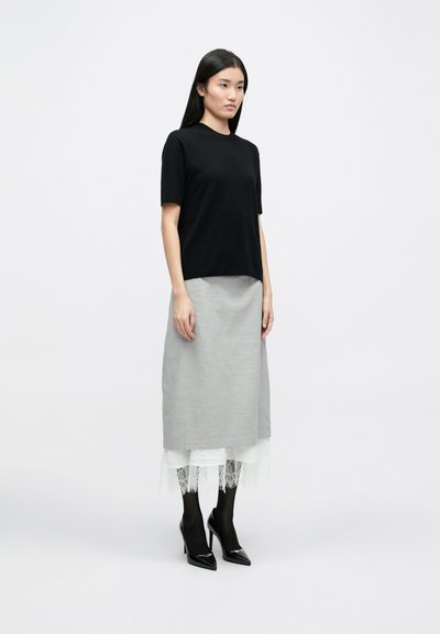 Black short-sleeve top, gray knee-length skirt with lace hem, black high-heeled shoes, worn with sheer black tights, minimalist design.