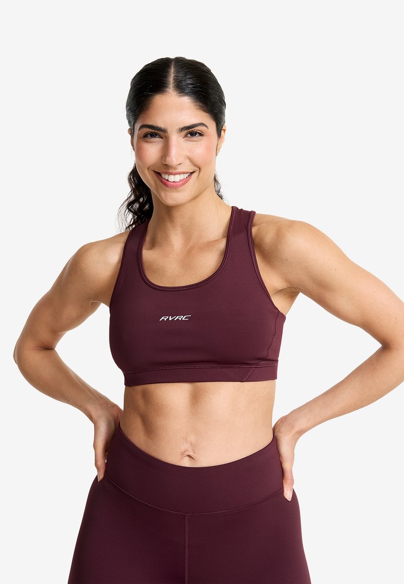 Mörkröd sport-bh med en åtsittande passform, med rund halsringning och "RVRC"-logotypen i vitt. Slät tyg och minimal sömnadsdetalj.