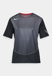 Black and dark gray Nike sports shirt with short sleeves, curved line patterns, and a red inner collar against a white background.
