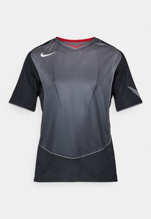 T-shirt de sport Nike noir et gris foncé à manches courtes, avec des motifs de lignes courbes et un col intérieur rouge sur fond blanc.
