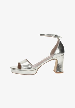 Sandal de tacón alto metálico plateado con diseño de punta abierta, correa en el tobillo y tacón cuadrado. Presenta una plataforma para mayor altura.