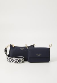 Sacs en cuir navy avec des accessoires en ton doré, présentant une finition texturée. Un sac possède une fermeture à glissière, tandis que l'autre a un rabat.
