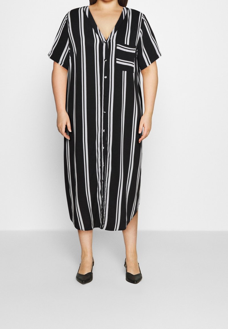 Czarna i biała, w paski, maxi sukienka z dekoltem w serek, krótkimi rękawami, z przodu zapinana na guziki i z kieszonką na piersi. Gładki materiał i luźny krój.