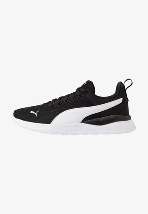 Baskets d’athlétisme noir et blanc avec tige en mesh, semelle blanche, fermeture à lacets, et logo Puma blanc sur le côté et à l’avant.