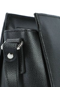 Borsa a mano in pelle nera con superficie strutturata, dotata di dettagli in metallo argentato e chiusura a soffietto. Forma compatta e rettangolare.