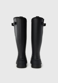 Μαύρες ψηλές μπότες από λάστιχο με ομαλή υφή, ρυθμιζόμενες λουρίδες και ανθεκτική μαύρη σόλα. Σχεδιασμένες με ευθύγραμμη σιλουέτα.