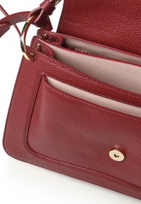 Borsa a tracolla in pelle rossa con superficie testurizzata, dotata di accessori in oro, tasca frontale e più scomparti interni.