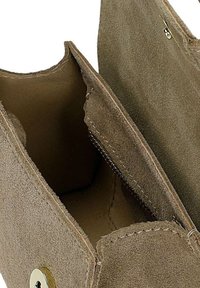 Portefeuille en daim marron ouvert montrant les compartiments intérieurs et une fermeture à pression métallique sur le rabat.