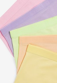 Penki poros besiūlių apatinių kelnaičių, išdėstytų pastelinių spalvų: rožinės, violetinės, žalios, oranžinės ir geltonos, su raukšlėtomis elastingomis juostelėmis.