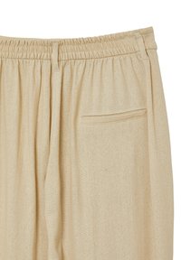 Beige Hose mit elastischem Bund und glatter Textur, ausgestattet mit einer einzelnen Gesäßtasche und dezenten Falten für ein zusätzliches Designdetail.