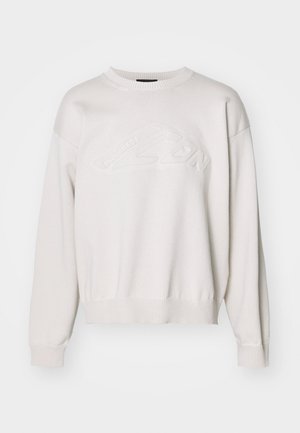 Hvid strikket sweatshirt med rund hals og ribbet kant. Har et tekstureret logo-design fortil og skuldre, der falder.