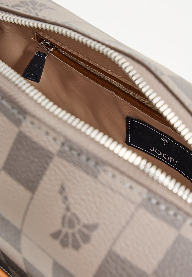 Beige Lederhandtasche mit Reißverschluss, ausgestattet mit einer glatten Textur, beige Innenfutter und einem kleinen Logoetikett. Karomuster sichtbar.