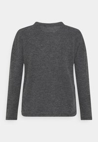 Graues Langarmoberteil aus geripptem Stoff, mit rundem Ausschnitt und seitlichen Schlitzen, einem weichen Material und lockerer Passform.