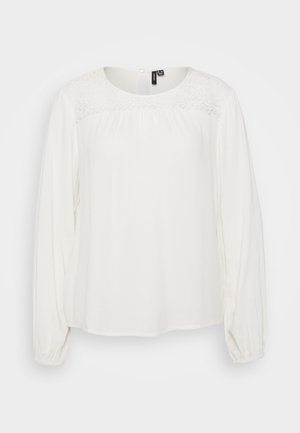 White blouse with a round neckline, gathered detailing at shoulders, long sleeves with elastic cuffs, and lace accent across the chest.
