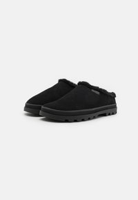 Czarne buty wsuwane wykonane z zamszu, z miękkim puszystym wykończeniem wewnętrznym i teksturowaną gumową podeszwą o wzorzystym bieżniku zapewniającym przyczepność.