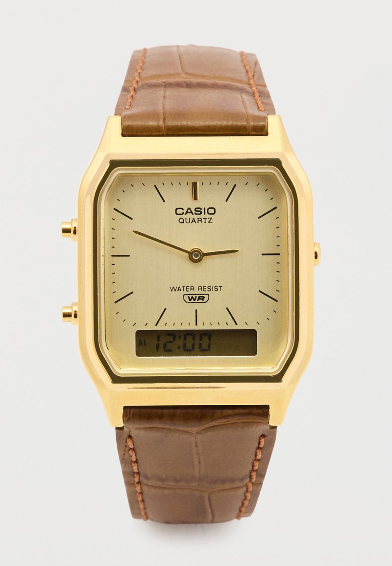 Złoty kwadratowy zegarek Casio na kwarc, z beżową tarczą, czarnymi oznaczeniami i wyświetlaczem cyfrowym. Brązowy skórzany pasek w wzór krokodyla.