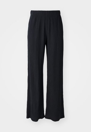 Pantaloni negri, cu croi larg, fabricate dintr-un material texturat, cu un cordon elastic la talie. Prezintă o croială relaxată și un design moale, fluid.