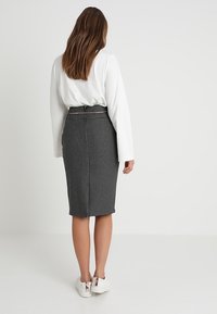 Černobílá kostkovaná tužková sukně s texturovanou látkou, délka do poloviny lýtek a se zúženým pasem, doplněná bílými teniskami.