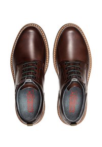 Chaussures en cuir marron avec une finition lisse, bout rond, lacets bleus, détails perforés et une semelle contrastante avec une couture décorative.