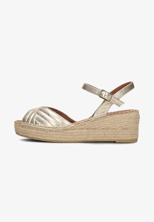 Metallic gold wedge sandals with a crisscross design, jute rope sole, and adjustable ankle strap. Upper has a textured finish.