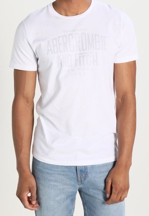 White cotton t-shirt featuring a faded graphic in the center reading "Abercrombie and Fitch" with a crew neckline and short sleeves.