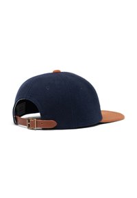 Gorra de lana azul marino con visera de ante marrón y correa de cuero ajustable. Presenta un pequeño botón en la parte superior y detalles de costura.